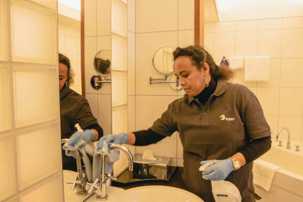 Kvinde igang med at rengøre hotelbadeværelse